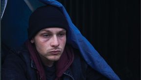 Young man, looking tired, in a tent