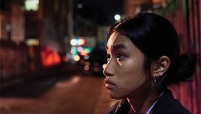 Young woman in the street at nighttime, looking uncertain