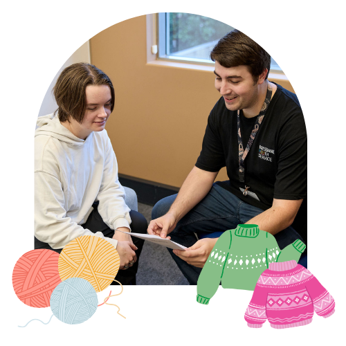 Youth worker talks to young person in meeting room