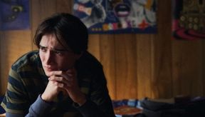 Young man in his bedroom, looking scared
