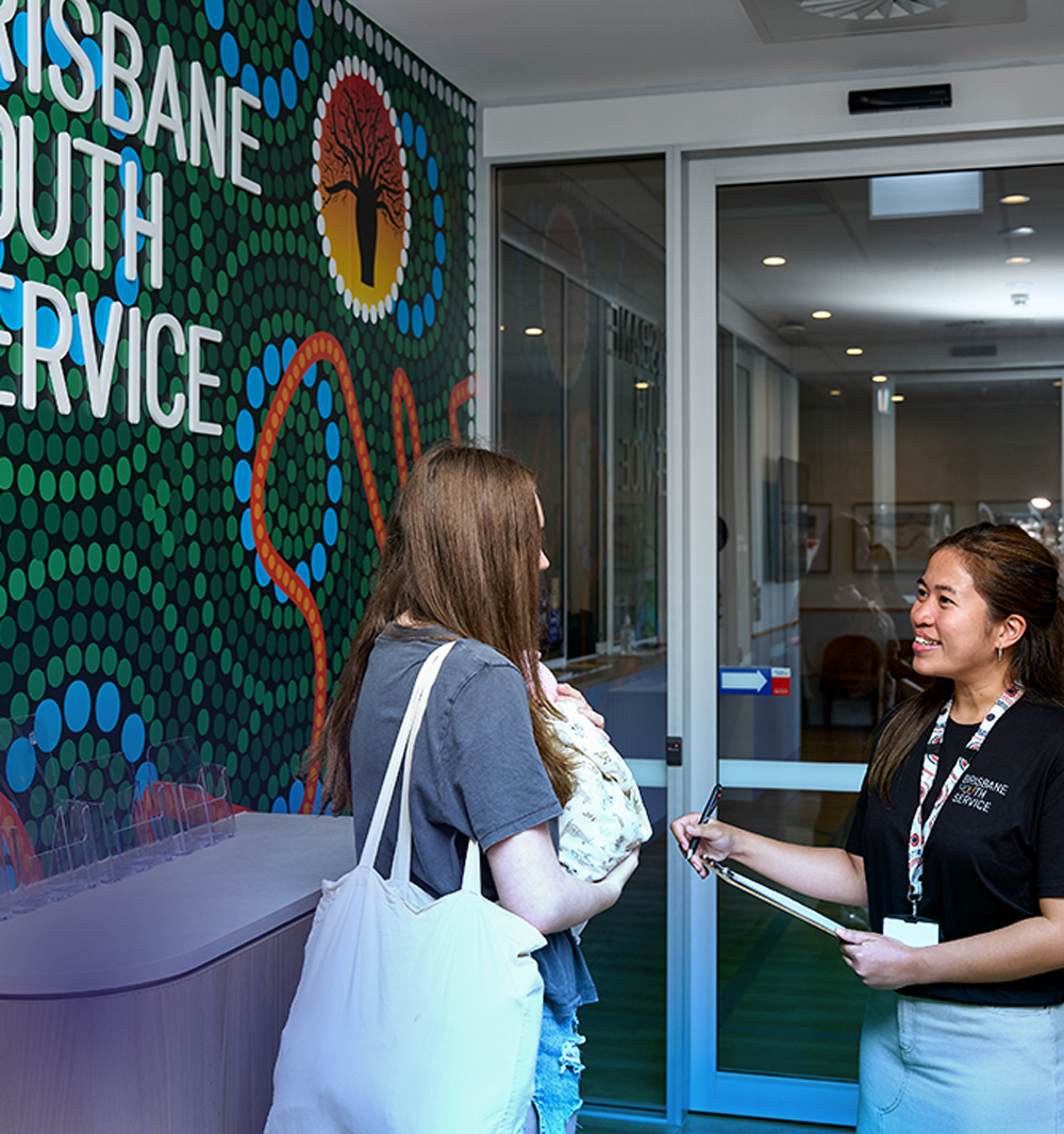 Young person and baby greet support worker at Brisbane Youth Service